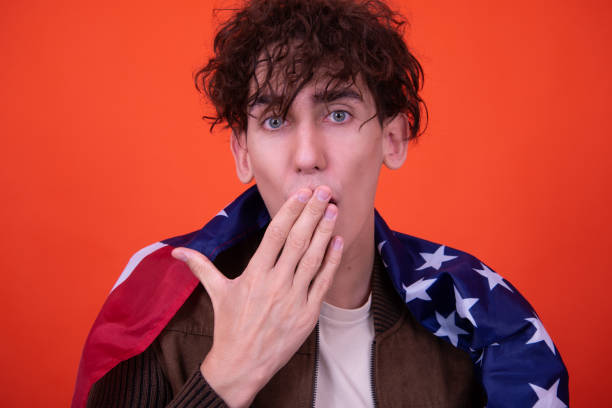 istock Emotions of a young attractive guy. Orange background. 1414046916
