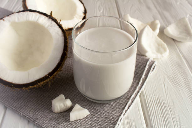 Coconut milk in the drinking on the white background. Close-up. Coconut milk in the drinking on the white background. Close-up. coconut milk stock pictures, royalty-free photos & images