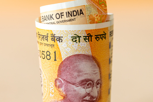 A rolled up roll of Indian money, New 200 rupee banknotes, financial business concept