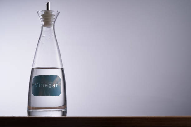 Two elegant glass bottles, one filled with olive oil and the other with balsamic vinegar, are beautifully arranged on a rustic wooden table, adding flavor to the culinary atmosphere.