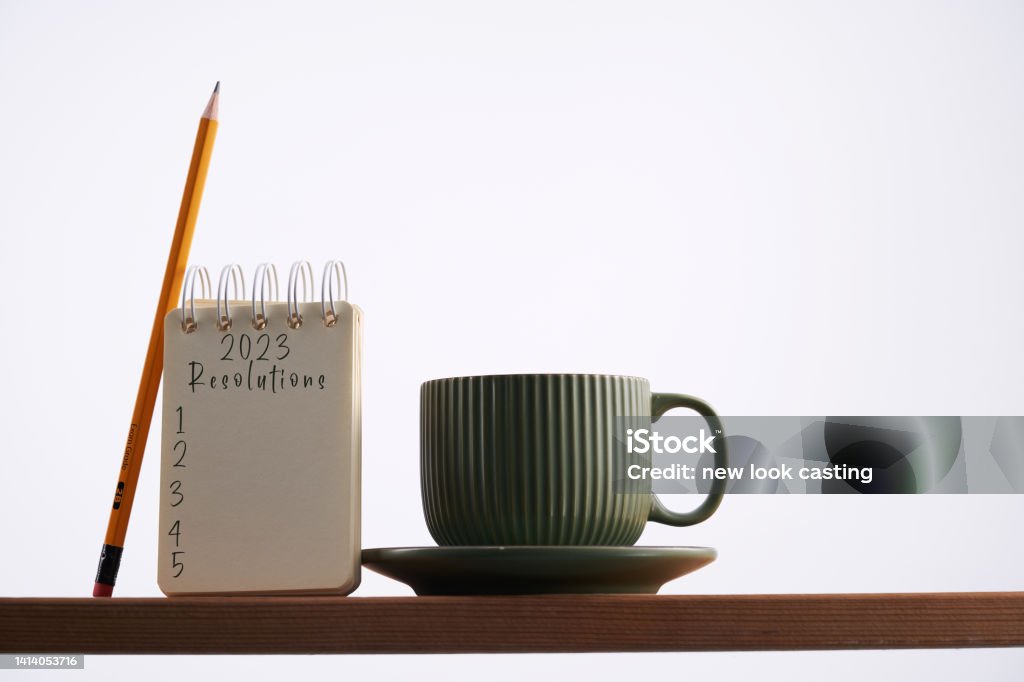 spiral note pad with text 2023 new year resolutions and coffee cup New Year Resolution Stock Photo