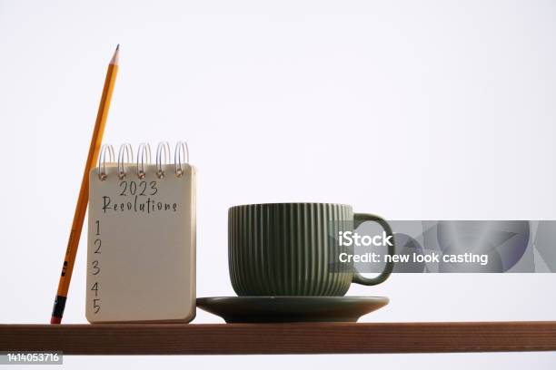 Spiral Note Pad With Text 2023 New Year Resolutions And Coffee Cup Stock Photo - Download Image Now