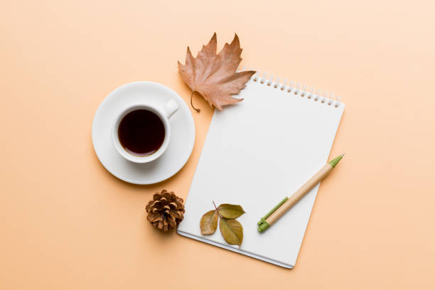 istock Autumn composition: fallen leaves and notebook mock up on colored background. Top view. Flat lay with copy space 1414055519