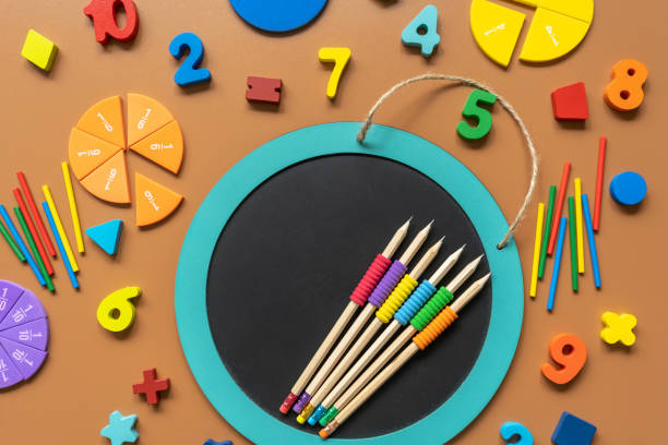 istock Closeup school board, mathematical fractions, pencils, notebook, ruler, accessories for school on brown table. Back to school, education background 1414056418