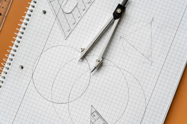 Close up Compass and ruler on the open notebook. Mathematical accessories, back to school background