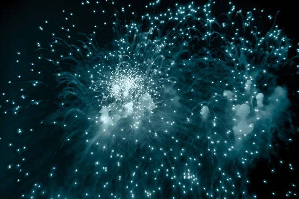 Blue holiday fireworks background with sparks, colored stars and bright nebula on black night sky universe. Amazing beauty colorful fireworks display on celebration, showing. Holidays backgrounds