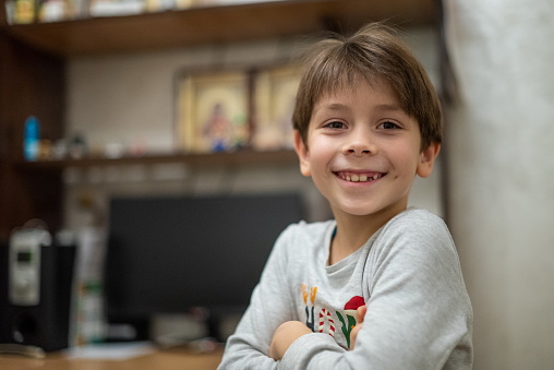 Head shot of healthy kid, Portrait happy child looking at camera with smiling face, candid shot cute little boy relaxing stay at home during covid lock down.Positive children concept, Social distancing.