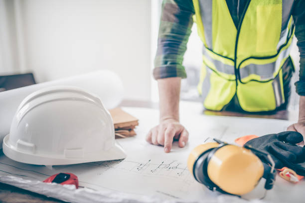 Site superintendent verifying the architectural drawings Site superintendent verifying the architectural drawings superintendent stock pictures, royalty-free photos & images
