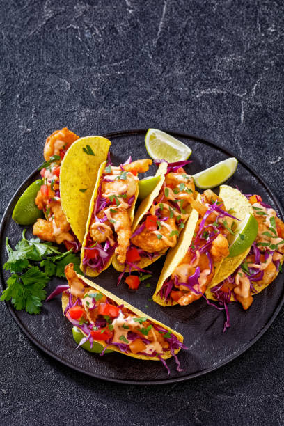 istock Bang Bang Shrimp Tacos on black plate with sauce 1414067527