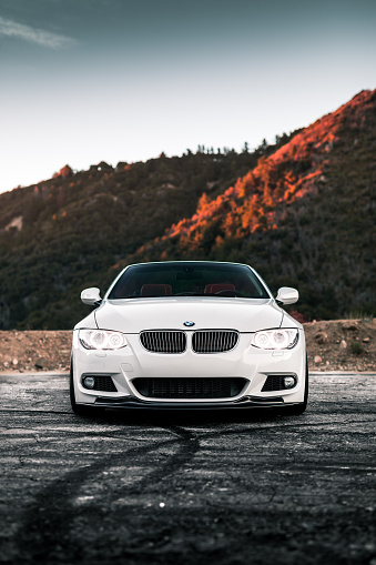 LA, CA, USA
August 2, 2022
White BMW 335i Convertible parked on asphalt with mountains in the background