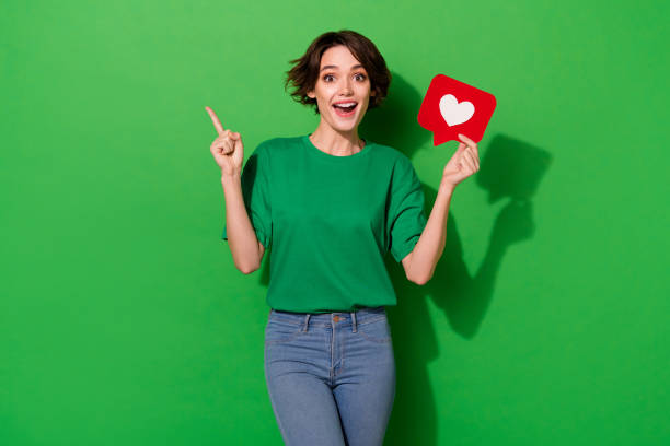 portrait of cheerful nice person indicate finger empty space blank isolated on green color background - like sign imagens e fotografias de stock