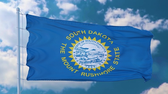 South Dakota flag on a flagpole waving in the wind, blue sky background. 3d illustration.