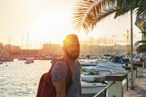 Bearded man portrait outdoor during golden hour time, summer vacation vibes, candid lifestyle, looking at camera