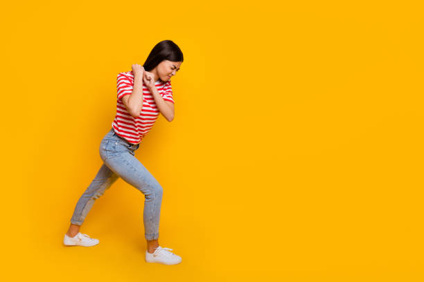 full size profile photo of pretty girl arms pull heavy empty space walk isolated on yellow color background - tug o war imagens e fotografias de stock