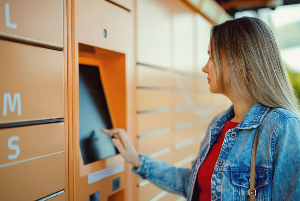 istock Woman picks up mail from automated self-service post terminal machine. 1414079378