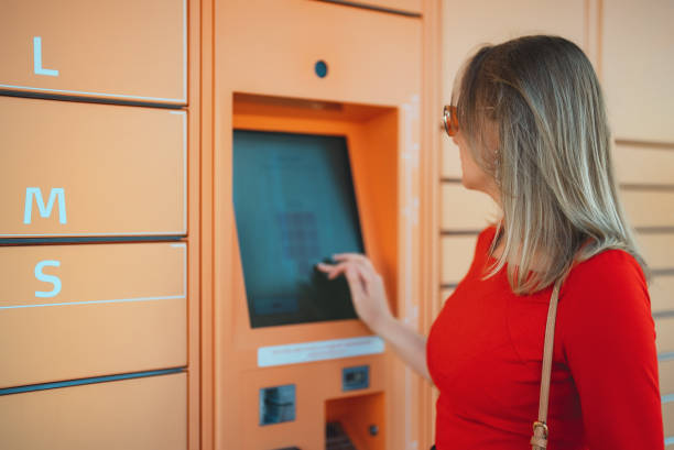 istock Woman picks up mail from automated self-service post terminal machine. 1414079383