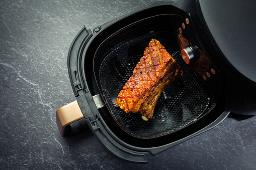 Cooking crispy pork belly in air fryer. Fast and easy crispy food cooking with little or no fat by circulating hot air inside the basket