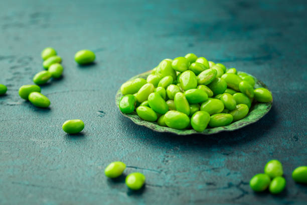 シアンの背景に生枝豆のボウル - soybean bean edamame pod ストックフォトと画像