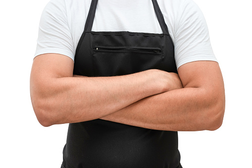 Torso of a man in a black apron with crossed arms isolated on a white background. Chef or waiter concept mockup.