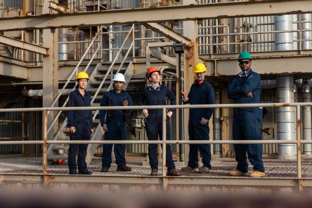 istock Line of Industrial Workers Looking from Walkway at Camera 1414082189