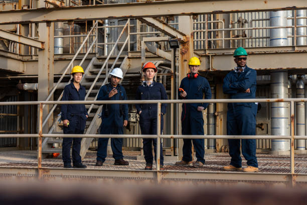 istock Row of Industrial Workers Wearing Safety Gear Looking at Camera 1414082191