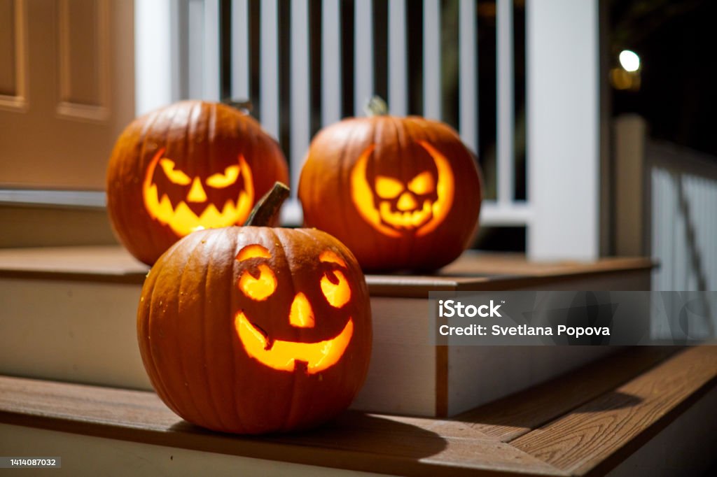 Halloween Pumpkins on a porch Halloween Jack-o'-lantern pumpkins lit insight on a porch Jack O' Lantern Stock Photo