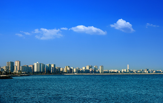 Waterfront cityscape with tall buildings over blue sky in Mersin, Turkey