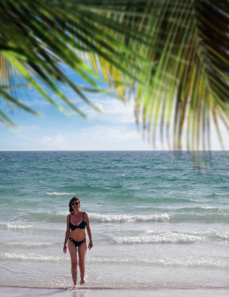 istock Beautiful woman in bikini on tropical beach vacation 1414090385