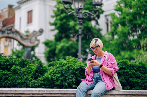 istock Young plus size woman using smartphone while walking in the city. 1414091485