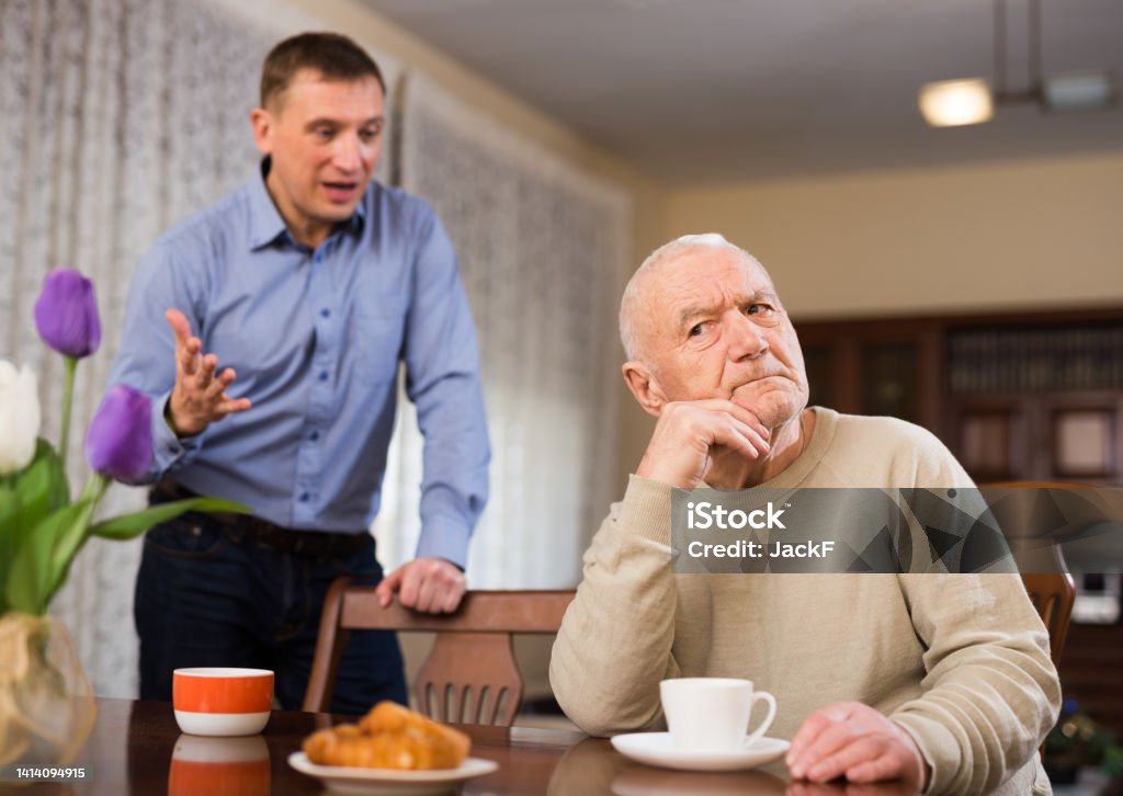 Man and his adult son having conflict Annoyed elderly man and his adult son having conflict at home Adult Offspring Stock Photo