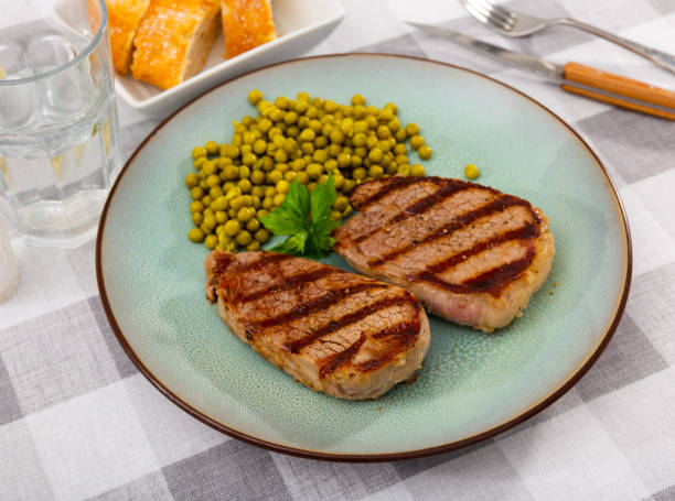 istock Beef steak with green peas served on plate 1414096454