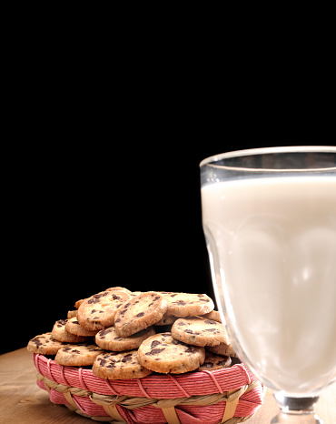 cup of espresso and chocolate chip cookies on dark wooden table