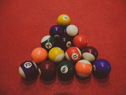 billiard balls on red pool table