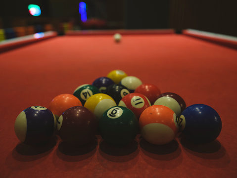 billiard balls on red pool table