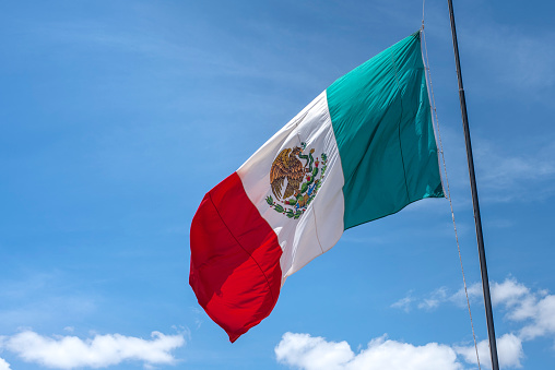 Mexican flag waving with blue sky and clouds in Mexico City - Flag Waving - Mexico Flag