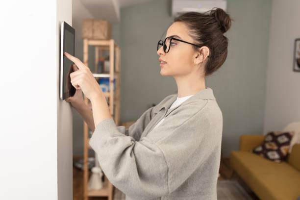 istock Young woman adjusting a smart house system 1414107138