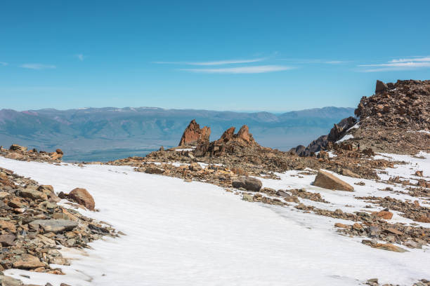 Scenic mountain landscape with old rocks and stones among snow in sunlight. Awesome alpine scenery with stone outliers on high mountain under blue sky in sunny day. Sharp rocks at very high altitude. paisaje escénico de montaña con rocas y piedras antiguas entre la nieve a la luz del sol. impresionante paisaje alpino con valores atípicos de piedra en alta montaña bajo el cielo azul en un día soleado. rocas afiladas a muy gran altitud.