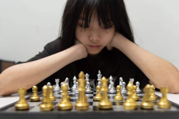 cute young girl playing chess using her mind. stock photo