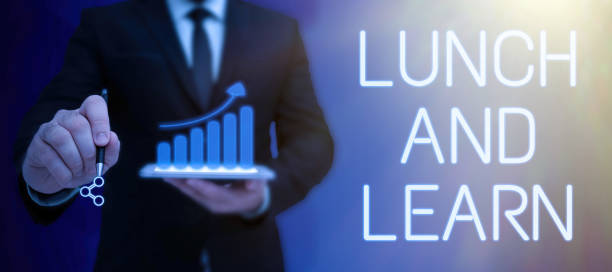 istock Conceptual display Lunch And Learn. Business concept Have meal and study motivation for education learning eating Lady in suit holding pen symbolizing successful teamwork accomplishments. 1414108084