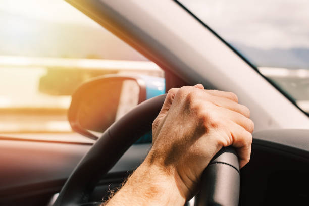 istock Man's hand on the steering wheel close-up 1414110422