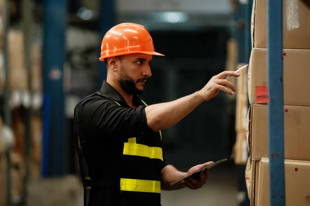 istock Warehouse workers selling stock checks with tablets . 1414126943