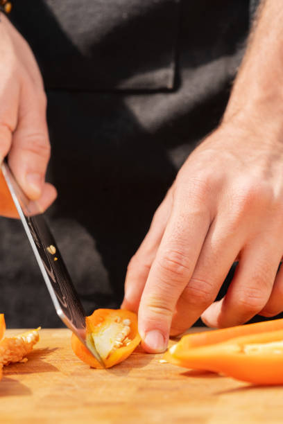 istock Cook removing the seeds from a red pepper with a knife 1414126980