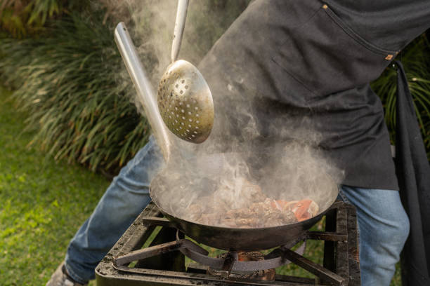 istock Man cooking meat with veggies in a garden 1414128248