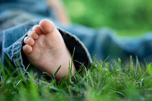 close up of baby feet in the grass