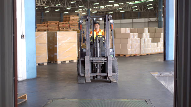 istock Man driving a forklift in warehouse. 1414129820