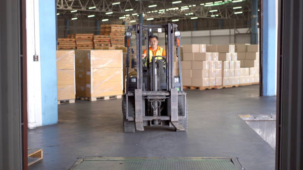Man driving a forklift in warehouse. stock photo