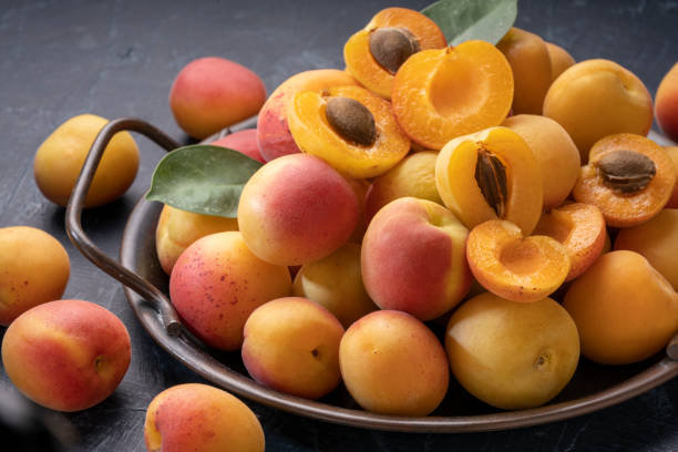 istock Red Apricot fruit with leaf on black background, Fresh Apricot on iron plate over black Background. 1414131104