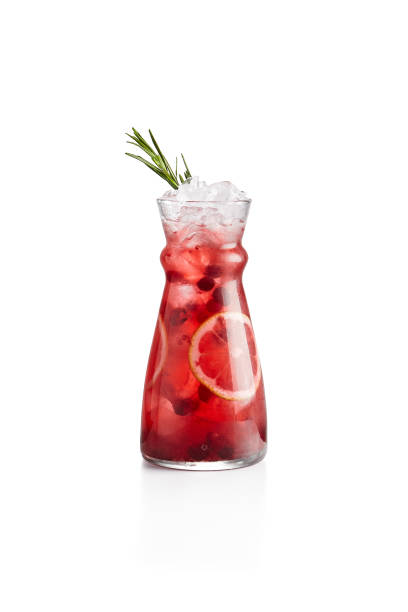 cranberry-limonade mit orange und rosmarin im krug. cranberry-cocktail auf weißem hintergrund. kalter cocktail im winter barkarte. alkoholfreie getränke. preiselbeer-getränk. - red jug stock-fotos und bilder