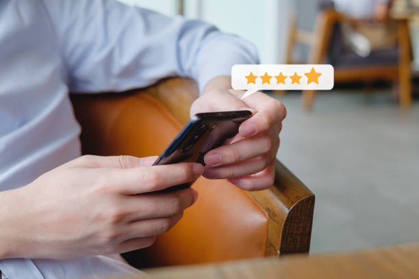 istock Customer hand press on smartphone screen with gold five star rating feedback icon excellent rank level for giving best score point to review the service , ranking experience, evaluate quality. 1414137055