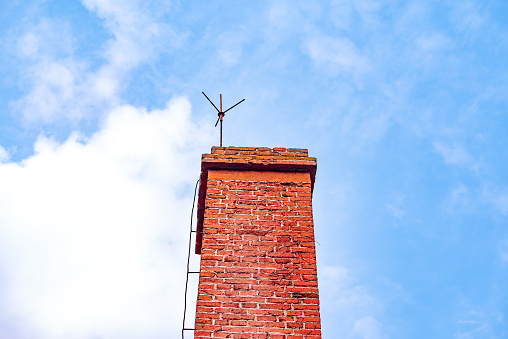 Close up of red brick chimney with blue sky background